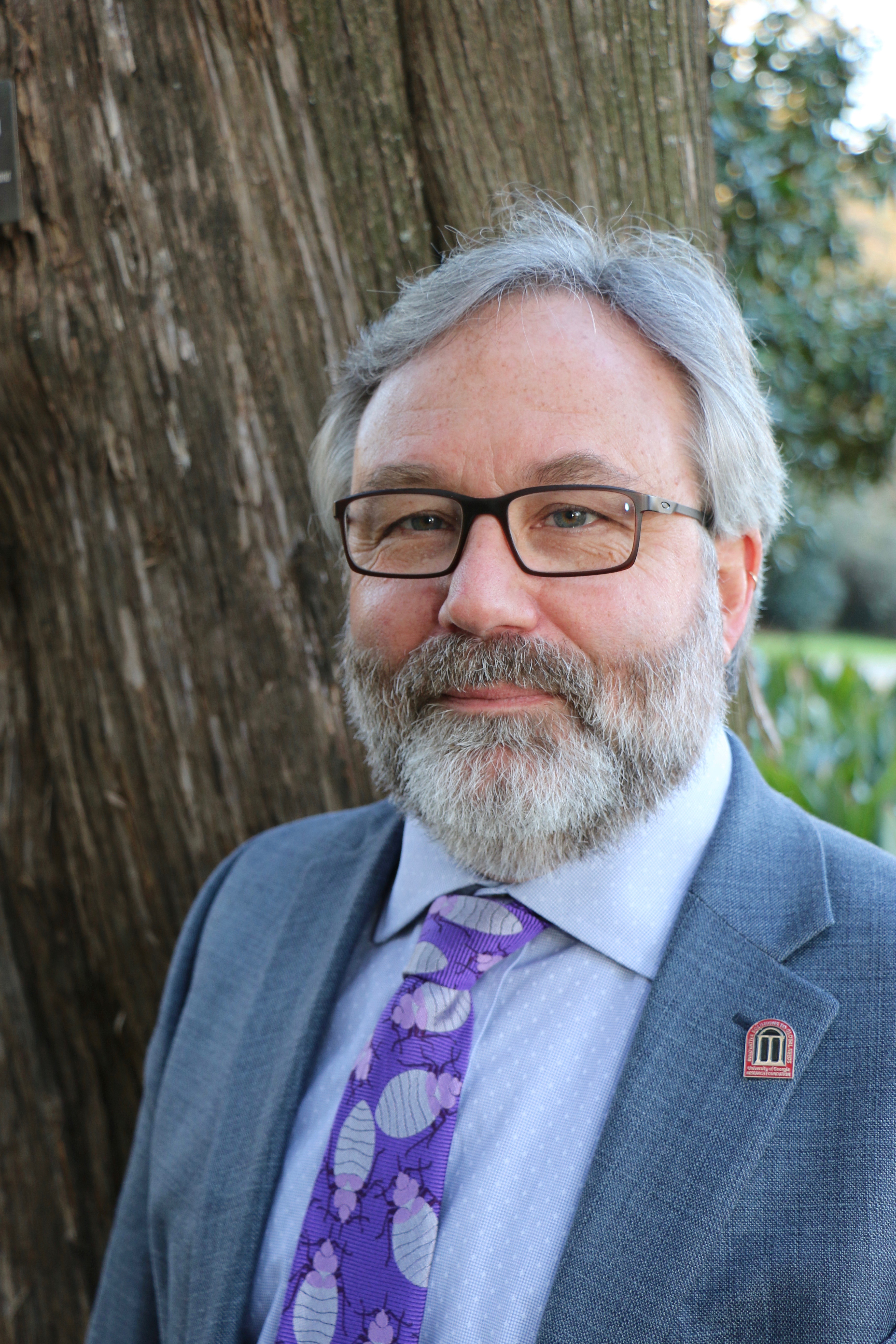 A headshot of Dr. Allen Moore in front of a tree.